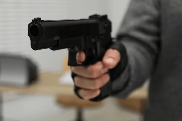 dangerous-criminal-gun-indoors-closeup-600nw-2497038305